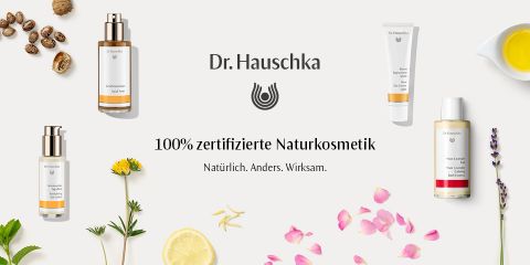 Das Bild zeigt verschiedene Hautpflegeprodukte von Dr. Hauschka, darunter Cremes und Öle, sowie natürliche Elemente wie Blumen und Samen. Der Text lautet: „100 % zertifizierte Naturkosmetik. Natürlich. Anders. Wirksam.“.