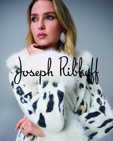 Eine Frau in einem weißen Kunstpelzmantel mit schwarzen Punkten posiert nachdenklich. Der Name "Joseph Ribkoff" ist in schwarzer Schrift über das Bild geschrieben.