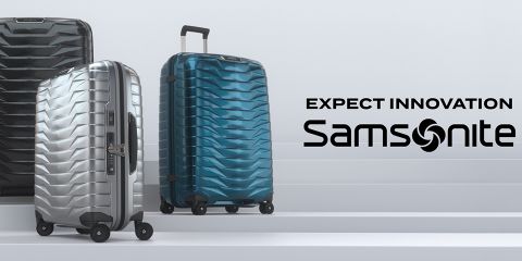 Drei Samsonite-Koffer in Silber, Schwarz und Blau stehen auf einer Treppe. Auf der rechten Seite des Bildes steht der Text „Expect Innovation Samsonite“.