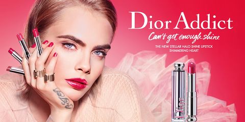 Eine Person mit blondem Haar ist von fünf Lippenstiften umgeben, jeder in einem einzigartigen Rosaton. „Dior Addict: Can't get enough shine“ wird angezeigt und wirbt für die Lippenstiftlinie Stellar Halo Shine. Rechts ist eine Nahaufnahme eines Lippenstiftgehäuses zu sehen.