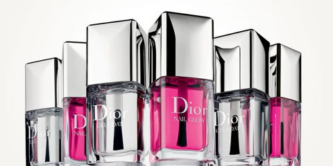 Eine Gruppe von Dior-Nagellackflaschen mit Chromdeckeln, die rosafarbenen Lack enthalten, angeordnet vor einem hellen Hintergrund.