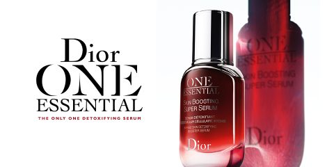 Eine elegante Flasche Dior One Essential Skin Boosting Super Serum wird mit ihrer Spiegelung auf einer weißen Oberfläche präsentiert. Der Name und der Slogan des Produkts betonen seine entgiftende Wirkung. Der Hintergrund ist minimalistisch und verstärkt das luxuriöse Gefühl.