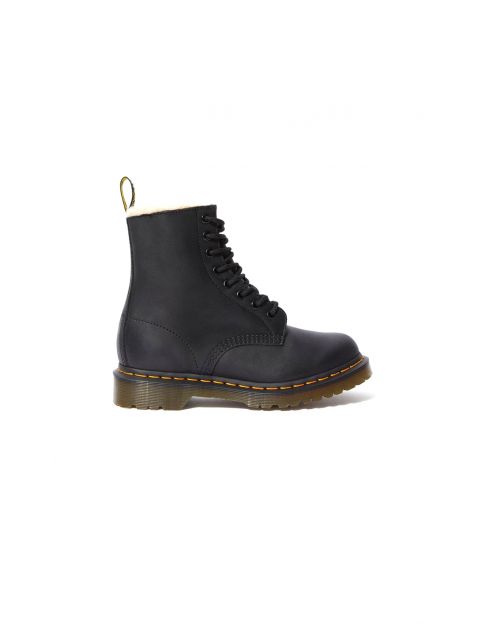 Schwarzer Kampfstiefel mit gelben Nähten und einer Schlaufe an der Rückseite. Der Stiefel hat vorne eine Schnürung und eine dicke, durchscheinende Sohle. Der Hintergrund ist schlicht weiß.