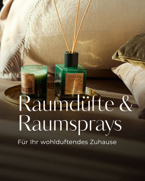 Grüne Kerze und Schilfrohrdiffusor auf einem goldenen Tablett, mit kuscheligen Decken; deutscher Text wirbt für Raumdüfte und Sprays für ein duftendes Zuhause.