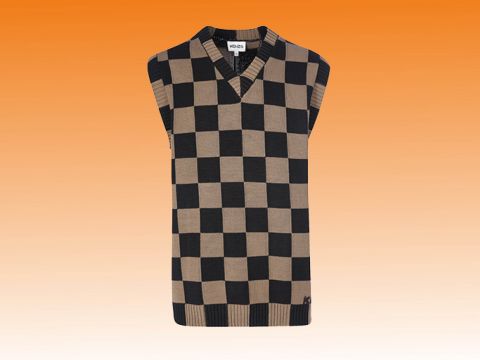 Ein ärmelloser Pullover mit einem schwarz-beigen Schachbrettmuster wird vor einem warmen, orangefarbenen Farbverlaufshintergrund dargestellt. Der Pullover verfügt über ein V-Ausschnitt-Design.