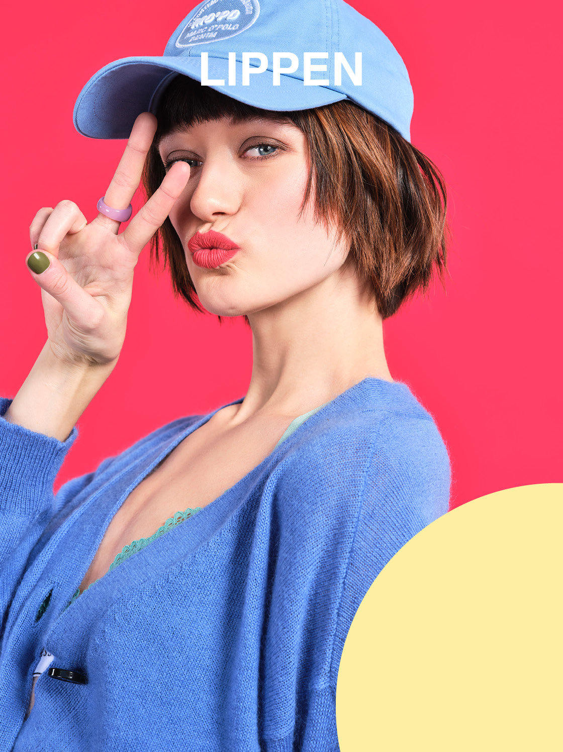 Eine Person mit blauer Mütze und Pullover posiert vor einem leuchtend rosa Hintergrund. Sie macht mit den Fingern vor dem Gesicht ein Peace-Zeichen und hat geschürzte Lippen. Oben im Bild erscheint das Wort „LIPPEN“.