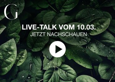 Vor einem Hintergrund aus üppigen grünen Blättern mit Wassertropfen ist ein Play-Button-Symbol zentriert. Der Text lautet: „LIVE-TALK VOM 10.03. JETZT NACHSCHAUEN“ mit einem stilisierten Buchstaben „G“ in der oberen linken Ecke.