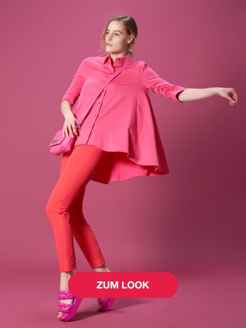 Eine Person posiert vor einem rosa Hintergrund. Sie trägt eine leuchtend rosa Bluse, rote Hosen und rosa Sandalen mit Absatz. Sie hält eine kleine rosa Handtasche in der Hand und auf einem Overlay-Button steht „Zum Look“.