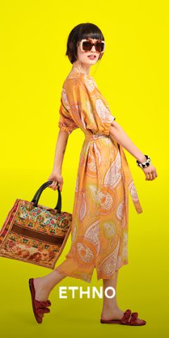 Eine stylische Frau in einem gemusterten gelben Kleid und Sonnenbrille posiert vor einem leuchtend gelben Hintergrund. Sie trägt eine bunt gemusterte Tasche und rote Sandalen. Unten steht der Text „ETHNO“.