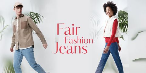 Links läuft ein junger Mann in beiger Jacke und Blue Jeans, rechts eine junge Frau in rotem Top, weißer Weste und Blue Jeans. In der Mitte ist der Text „Fair Fashion Jeans“ zu sehen. Den Hintergrund zieren grüne Pflanzenblätter.