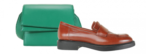 Ein brauner Lederloafer mit schwarzer Sohle steht vor einer grünen rechteckigen Handtasche mit Klappverschluss. Die Artikel sind vor einem schlichten weißen Hintergrund angeordnet.