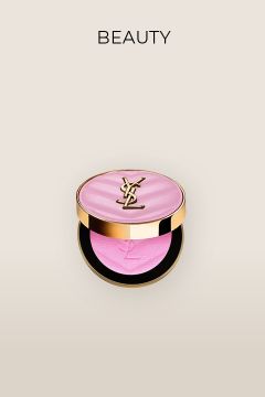Eine luxuriöse, runde Make-up-Dose mit goldenem YSL-Logo auf rosa Deckel. Im Inneren befindet sich ein leuchtend pinkes Produkt. Darüber ist auf beigem Hintergrund der Schriftzug „BEAUTY“ zu sehen.