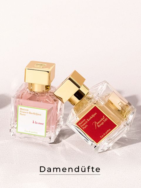Auf einer hellen Oberfläche stehen zwei Parfümflakons mit goldenen Verschlüssen. Der linke Flakon trägt die Aufschrift „À la Rose“, der rechte die Aufschrift „Baccarat Rouge 540“. Der Text darunter lautet „Damendüfte“.