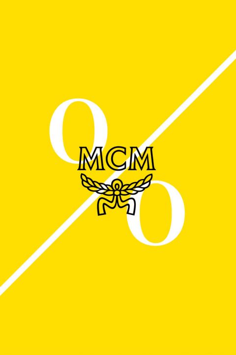 Hellgelber Hintergrund mit einer weißen diagonalen Linie. Die Großbuchstaben „MCM“ und ein Logo mit Lorbeerflügeln sind zentriert. Große weiße Ziffern „9“ und „0“ stehen auf beiden Seiten der Linie und geben möglicherweise einen Prozentsatz an.