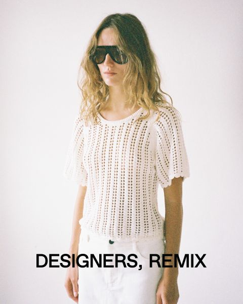 Eine Person mit langen Haaren, einer großen Sonnenbrille und einem gehäkelten weißen Oberteil steht vor einem schlichten Hintergrund. Am unteren Bildrand stehen die Worte „Designers, Remix“.