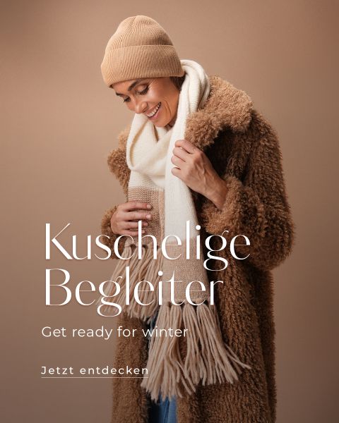 Eine Person in einem braunen Pelzmantel, einer beigen Mütze und einem weißen Schal lächelt warm vor einem braunen Hintergrund. Der Text auf dem Bild lautet: „Kuschelige Begleiter. Machen Sie sich bereit für den Winter. Jetzt entdecken.“.