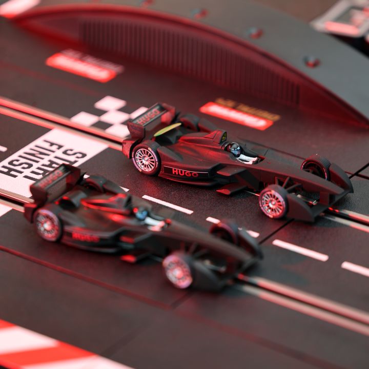 Zwei Modellrennautos auf einer Slotcar-Bahn mit karierter Start-/Ziellinie. Die Autos sind schnittig und dunkel, und die Bahn hat rote Akzente. Im Hintergrund ist eine gebogene Überführung zu sehen.