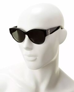 Ein weißer Schaufensterpuppenkopf trägt eine schwarze Sonnenbrille mit dickem Rahmen. Die Sonnenbrille hat ein kleines metallisches Zierelement an den Bügeln. Der Hintergrund ist schlicht weiß.