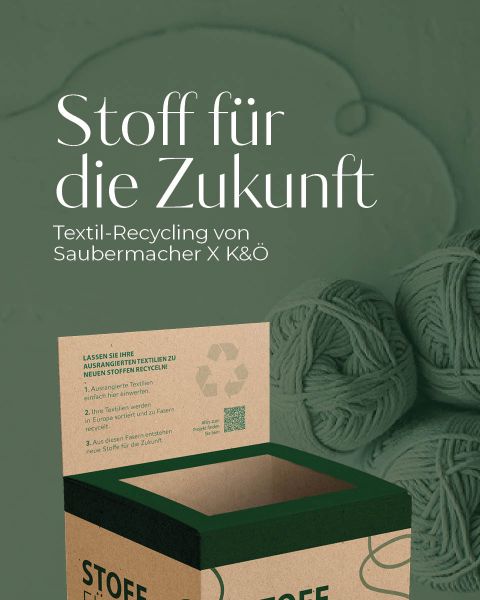 Ein Karton mit der Aufschrift „Stoff für die Zukunft“ ist geöffnet, um Textilien für das Recycling zu sammeln. Im Hintergrund Garnknäuel. Auf dem Karton sind Text und Recyclingsymbol zu sehen. Deutscher Text erklärt den Textilrecyclingprozess von Saubermacher und K&Ö.