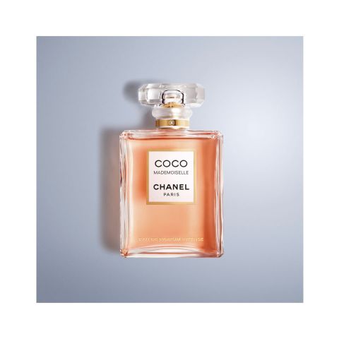 Eine Flasche Chanel Coco Mademoiselle Eau de Parfum Intense mit klarem, rechteckigem Korpus und facettiertem Verschluss. Auf der Vorderseite steht „Coco Mademoiselle Chanel Paris“. Die Flasche steht auf einer hellblau-grauen Oberfläche.