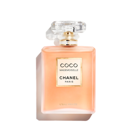 Eine quadratische Glasflasche mit Coco Mademoiselle Chanel-Parfüm und transparentem Verschluss. Die Flasche hat ein goldenes Etikett mit schwarzem Text auf der Vorderseite auf weißem Hintergrund.