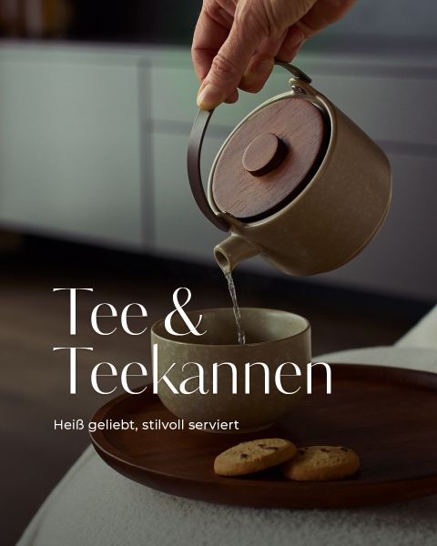 Eine Hand gießt Tee aus einer Keramikkanne in eine Tasse auf einem Holztablett mit zwei Keksen. Der deutsche Text lautet: "Tee & Teekannen. Heiß geliebt, stilvoll serviert.