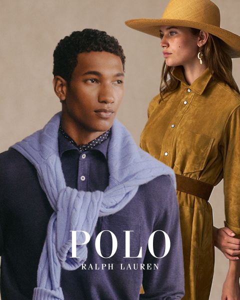 Ein Mann mit einem hellblauen Pullover über den Schultern und einem dunkelvioletten Hemd steht neben einer Frau in einem senffarbenen Kleid und einem breitkrempigen Hut. Unten ist der Text „Polo Ralph Lauren“ zu sehen.