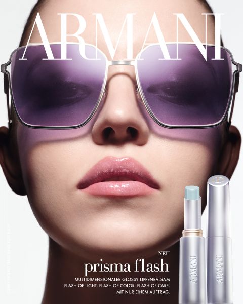 Die Schwarz-Weiß-Werbung für Giorgio Armanis Acqua di Giò Elixir zeigt einen Mann mit nacktem Oberkörper und lockigem Haar, der an felsigen Klippen am Meer sitzt und in die Ferne blickt. Im Vordergrund ist der Duftflakon zu sehen.