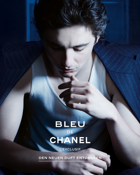 Ein Flakon des Parfums Chanel No. 5 steht neben zwei mit dunklen Bändern gebundenen Geschenkschachteln, die mit Schnee bestäubt sind, vor einem dunkelblauen, verschneiten Hintergrund. Der Text lautet "CHANEL Winter Constellation" und "Jetzt entdecken.".