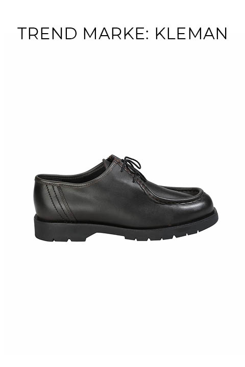 Ein schwarzer Lederschnürschuh mit einer dicken Profilsohle in Profilansicht auf weißem Hintergrund. Der Markenname "KLEMAN" erscheint über dem Schuh.