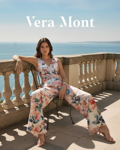 Eine Frau in einem grün schimmernden schulterfreien Kleid steht vor einer Steinmauer. Der Text "Vera Mont" erscheint am unteren Rand des Bildes.