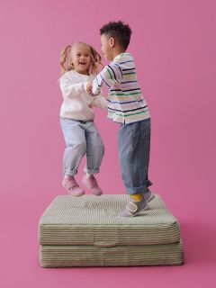 Zwei Paar Kleinkinderschuhe auf beigem Hintergrund: ein Paar ist helllila mit rosa Trägern, das andere hellblau mit gelben Trägern.