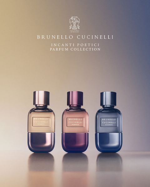 Sechs Parfümflakons von Brunello Cucinelli stehen in einer Reihe über einem Bett aus bunten Blumen und Grünpflanzen. Der Text darüber lautet „Brunello Cucinelli“ und darunter: „Incanti Poetici Parfum Collection“.