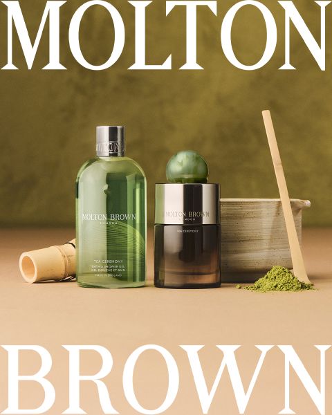 Flache Anordnung verschiedener Molton Brown-Flaschen und -Behälter auf hellem Hintergrund, mit dem Text „Molton Brown London, Unverwechselbarer Duft, Made in England“ in der Mitte. Überall sind kugelförmige Glasakzente verstreut.