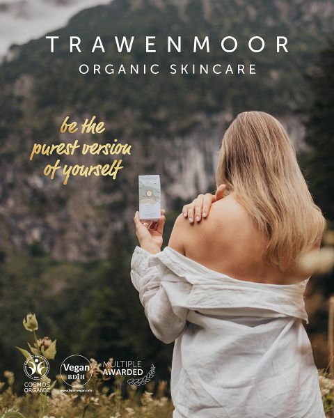 Eine Frau mit langen blonden Haaren steht mit abgewandtem Gesicht auf einem Feld und hält ein Hautpflegeprodukt in der Hand. Sie trägt ein schulterfreies Oberteil. Der Text lautet „Sei die reinste Version deiner selbst.“ Im Hintergrund sind Berge und Gras zu sehen. Auf dem Display ist „TRAWENMOOR ORGANIC SKINCARE“ zu sehen.