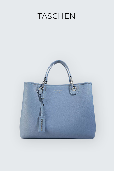 Eine blaue Lederhandtasche mit silbernen Beschlägen und einem Gepäckanhänger. Die Tasche hat zwei Tragegriffe und eine dezente Textur. Darüber prangt auf hellem Hintergrund der Schriftzug „TASCHEN“.