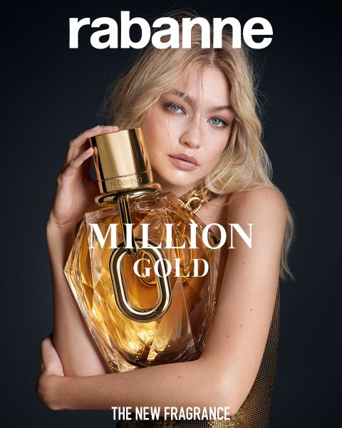 Eine Frau mit langen blonden Haaren hält vor dunklem Hintergrund einen großen, goldenen, rautenförmigen Parfümflakon mit der Aufschrift „Rabanne MILLION GOLD“. Der Text darunter lautet: „DER NEUE DUFT.“.