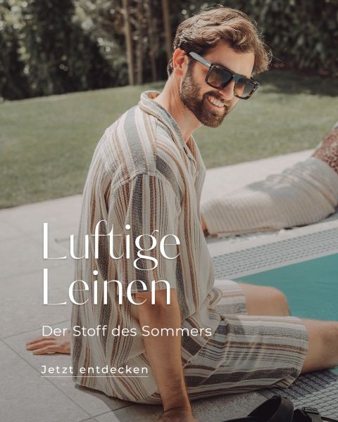 Ein Mann mit Sonnenbrille, gestreiftem Leinenhemd und Shorts sitzt an einem sonnigen Tag an einem Pool. Der deutsche Text auf dem Bild lautet: „Luftige Leinen. Der Stoff des Sommers. Jetzt entdecken.“.