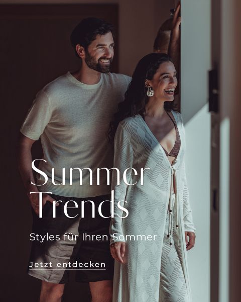 Ein lächelnder Mann und eine lächelnde Frau stehen zusammen in stilvollen Sommeroutfits in einer Tür. Überlagerter Text lautet: „Summer Trends. Styles für Ihren Sommer. Jetzt entdecken.“.