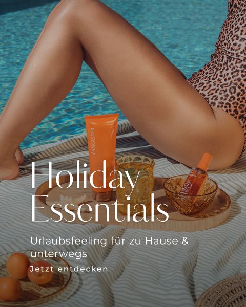 Die Beine einer Frau an einem Pool mit Sonnencreme, einem Getränk und einer kleinen Hautpflegeflasche auf einem Tablett. Der Text lautet: „Holiday Essentials. Urlaubsfeeling für zu Hause & unterwegs. Jetzt entdecken.“.