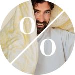 Ein lächelnder, bärtiger Mann hält zwei gemusterte gelbe Kissen. Ein großes weißes Prozentzeichen überlagert das runde Bild.