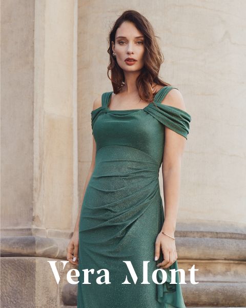Eine Frau in einem grün schimmernden schulterfreien Kleid steht vor einer Steinmauer. Der Text "Vera Mont" erscheint am unteren Rand des Bildes.
