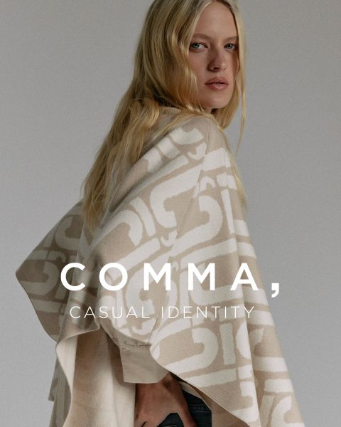 Eine Frau mit langen blonden Haaren trägt einen beige-weiß gemusterten Poncho. Sie steht seitlich und schaut über ihre Schulter. Der Text auf dem Bild lautet: "COMMA, CASUAL IDENTITY.