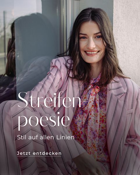 Eine lächelnde Frau in einem rosa gestreiften Anzug und einer geblümten Bluse sitzt an einem Fenster. Der Text lautet: "Streifen poesie. Stil auf allen Linien. Jetzt entdecken.