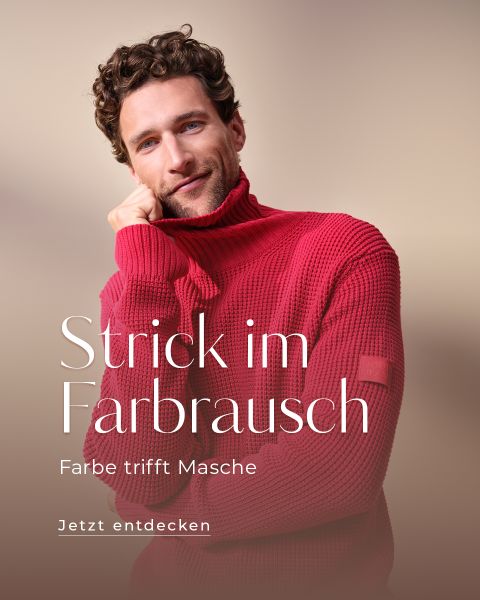 Ein Mann mit lockigem Haar, der einen leuchtend roten Rollkragenpullover trägt, lächelt sanft und stützt seinen Kopf auf seine Hand. Der deutsche Text lautet: "Strick im Farbrausch. Farbe trifft Masche. Jetzt entdecken.