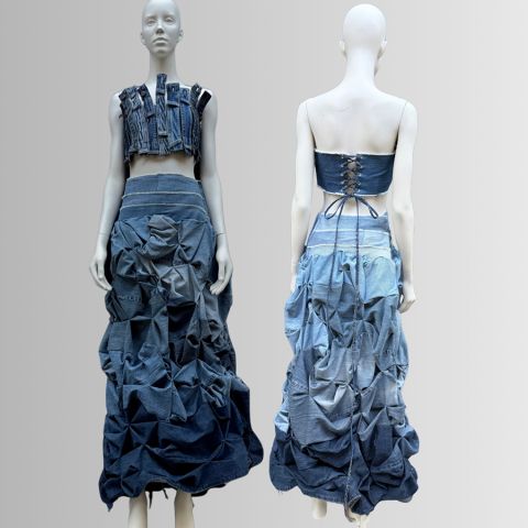 Zwei Schaufensterpuppen zeigen ein blaues Jeans-Outfit mit einem Träger-Crop-Top und einem langen, strukturierten, gerüschten Rock, sowohl in der Vorder- als auch in der Rückansicht.