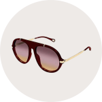 Rote Sonnenbrille im Fliegerstil mit goldenen Bügeln und getönten Gläsern mit Farbverlauf auf einem schlichten, hellen, runden Hintergrund.