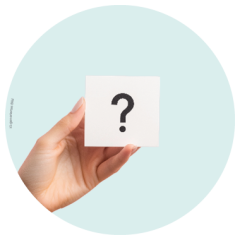 Eine Hand hält eine weiße Karte mit einem schwarzen Fragezeichen vor einem hellblauen runden Hintergrund.