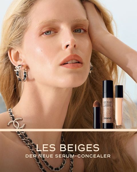 Eine Frau mit strahlender Haut posiert neben zwei Chanel Les Beiges Concealer-Produkten und trägt Silberschmuck vor einem zartbeigen Hintergrund.