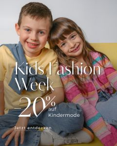 Zwei lächelnde Kinder in bunten Kleidern sitzen auf einem gelben Sofa. Der Text wirbt für die Kids Fashion Week mit 20 % Rabatt auf Kinderbekleidung.